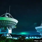 탄도 미사일 추적 시스템 - A high-tech military radar installation at dusk, featuring large, rotating high-frequency radar ante...